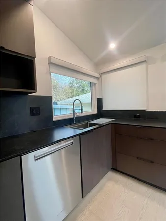 a kitchen with granite countertop a sink and a stove top oven