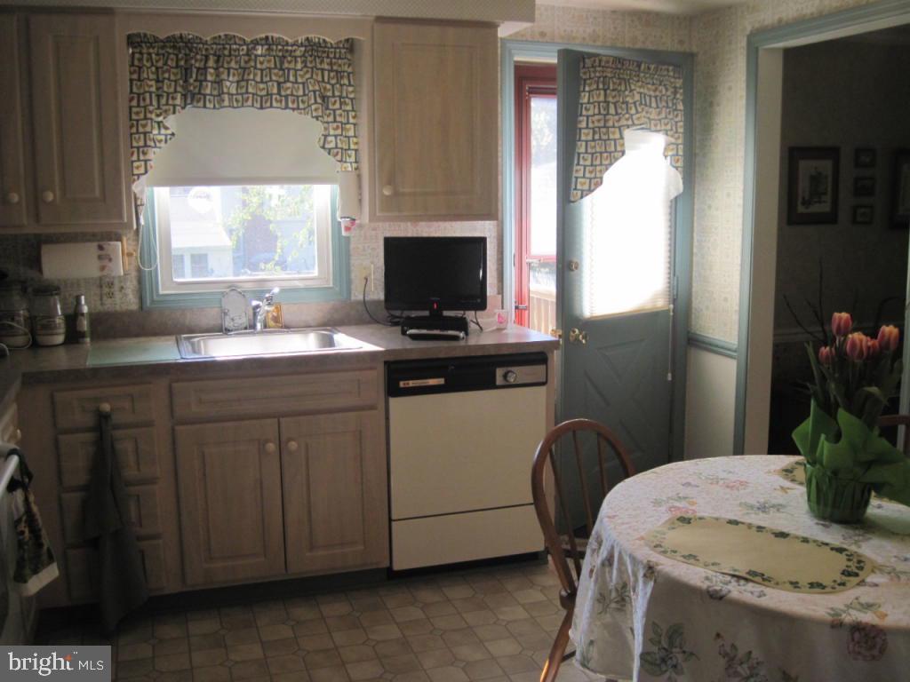 464 Longmeadow Road Lancaster, PA 17601 - Photo 5 of 17 a kitchen with stainless steel appliances granite countertop a stove a refrigerator a sink a dining table and chairs with wooden floor