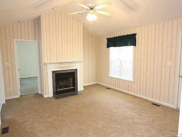 2809 Girth Lane Raleigh, NC 27603 - Photo 4 of 10 an empty room with windows and fireplace