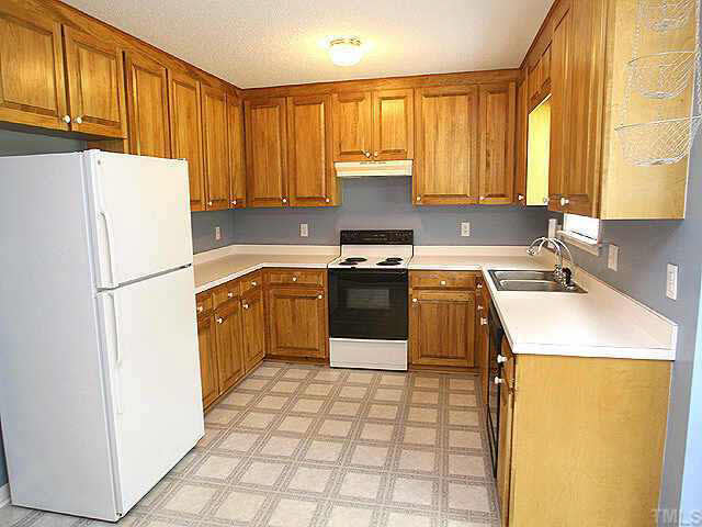 2809 Girth Lane Raleigh, NC 27603 - Photo 10 of 10 a kitchen with a sink a stove a refrigerator a washer dryer and cabinets
