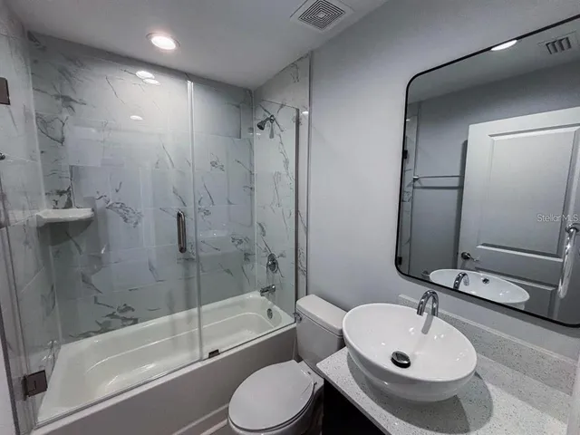 a bathroom with a sink toilet and shower