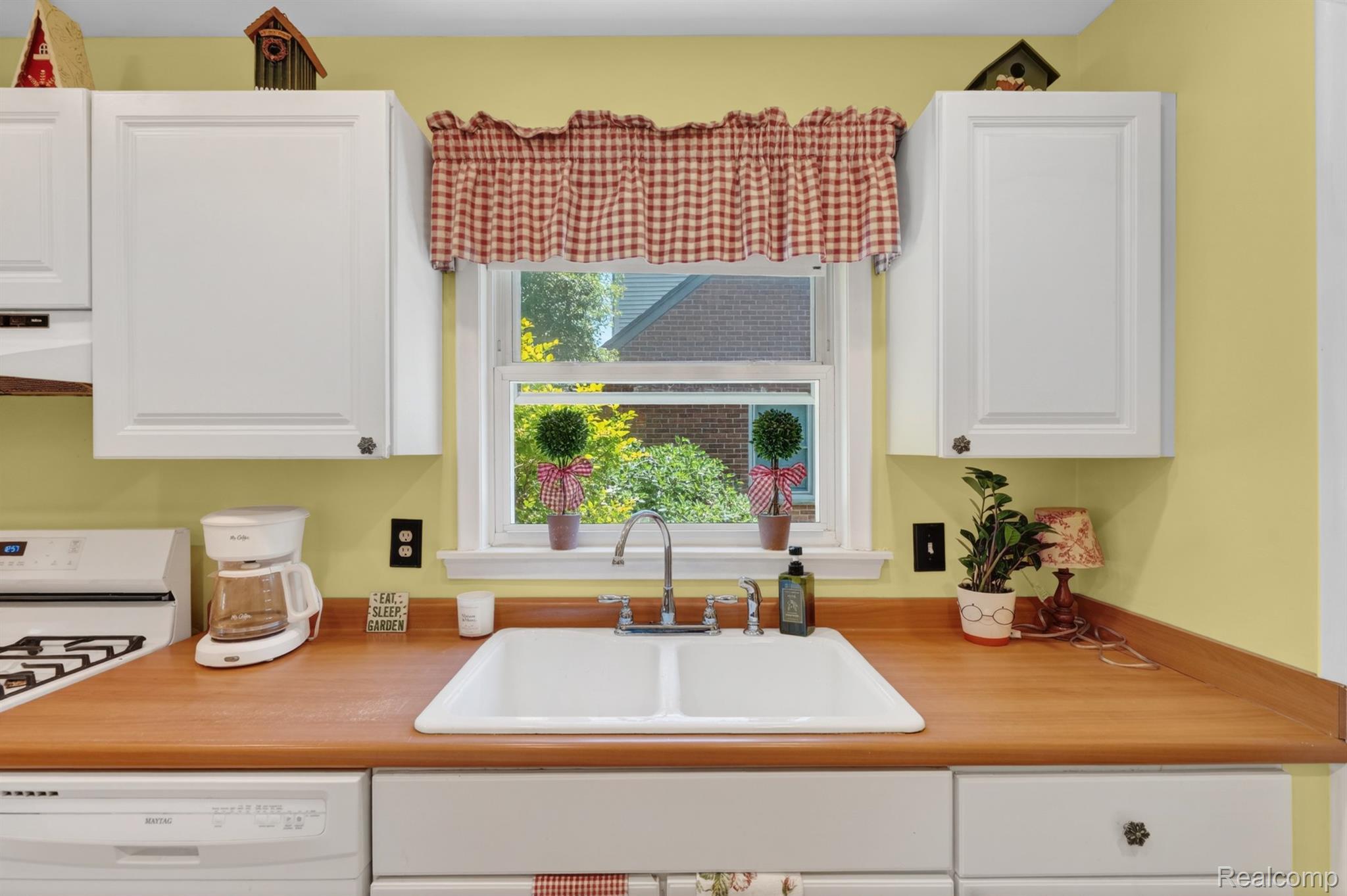 17386 Beverly Road Franklin, MI 48025 - Photo 11 of 28 Kitchen featuring a white double basin sink, wood-finish countertops, white cabinetry with decorative pulls, and a window with exterior views