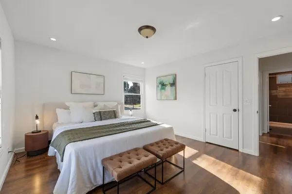 a bedroom with a bed and wooden floor