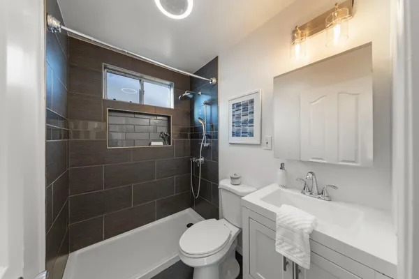 a bathroom with a sink a toilet and shower