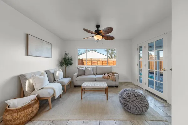 a living room with furniture a chandelier and a rug