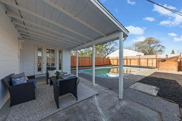 a view of backyard with swimming pool and outdoor seating