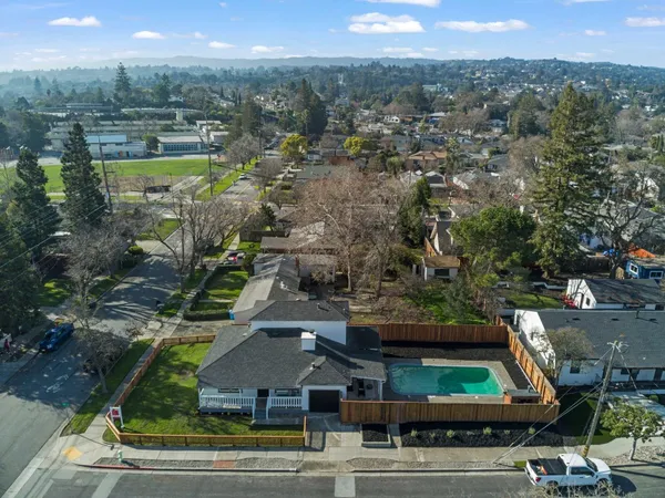 an aerial view of residential houses with outdoor space and parking