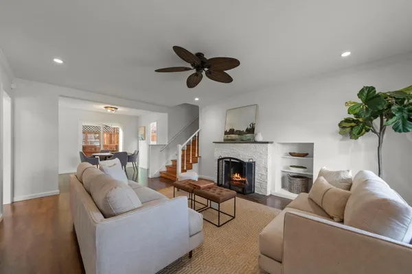 a living room with furniture a fireplace and a potted plant