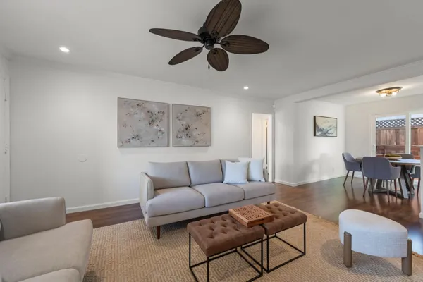 a living room with furniture and a ceiling fan