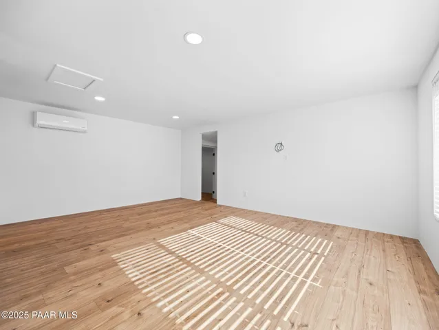 a view of a room with wooden floor and white walls