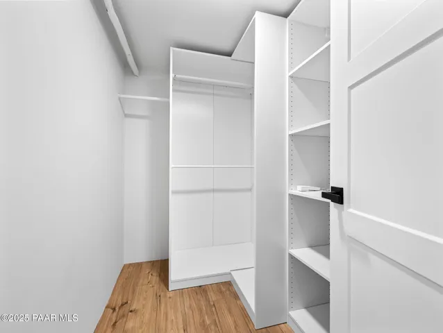 a view of walk in closet with empty racks