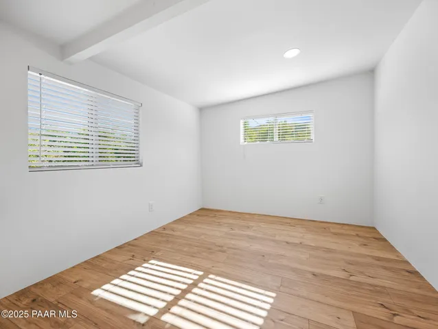a view of a room with wooden floor and a window
