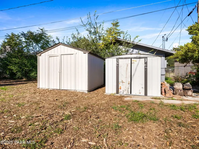 a view of a white house with a yard and large trees