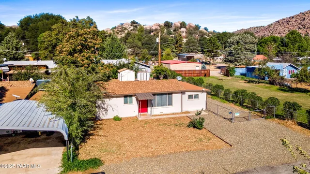 an aerial view of a house with swimming pool and large trees