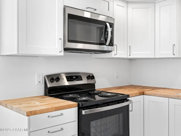 a kitchen with granite countertop white cabinets and white appliances