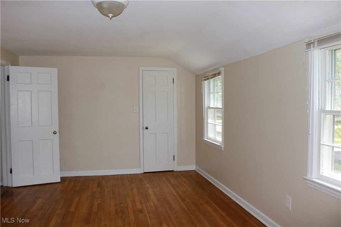 5095 Edenhurst Road Cleveland, OH 44124 - Photo 7 of 9 Unfurnished bedroom featuring multiple windows, dark hardwood / wood-style flooring, and lofted ceiling