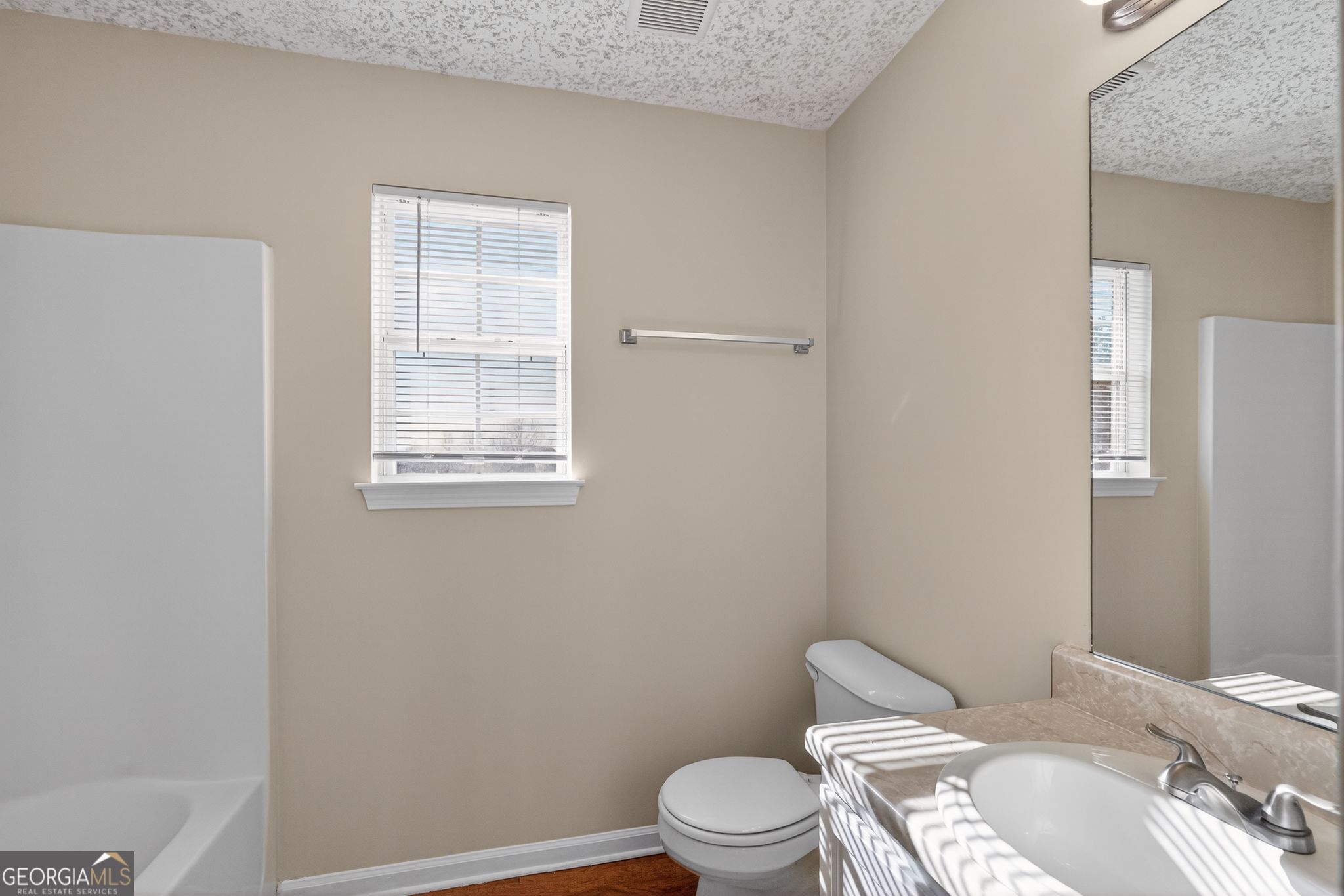 4627 Laura Place Lithonia, GA 30038 - Photo 24 of 33 a white toilet sitting next to a bathroom sink and vanity