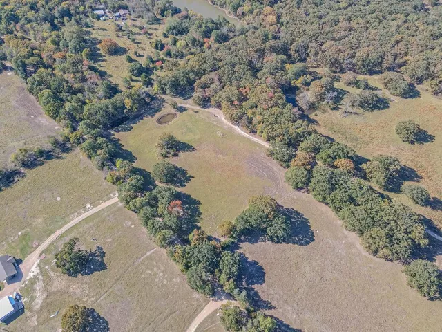 an aerial view of a house with a yard and mountain view in back