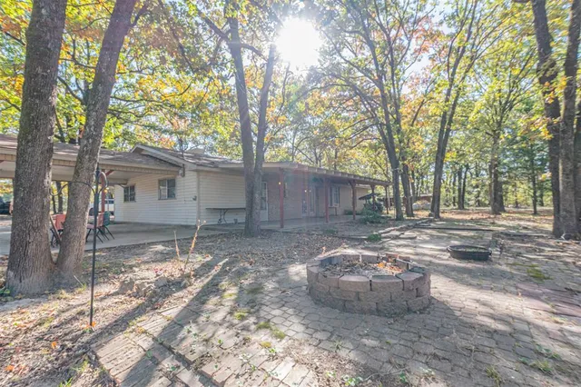 a view of a house with backyard and trees
