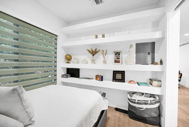 a bedroom with a bed and a large mirror