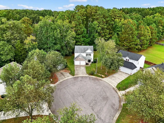 an aerial view of a house with a yard basket ball court and outdoor seating