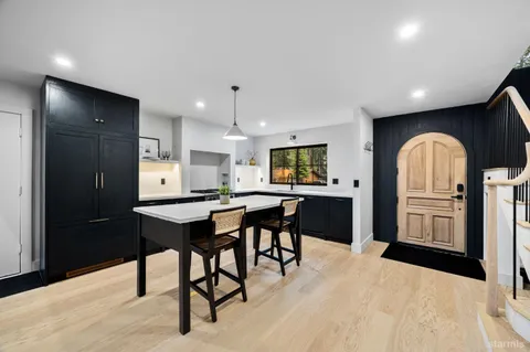 a open kitchen with stainless steel appliances kitchen island a table chairs sink and cabinets