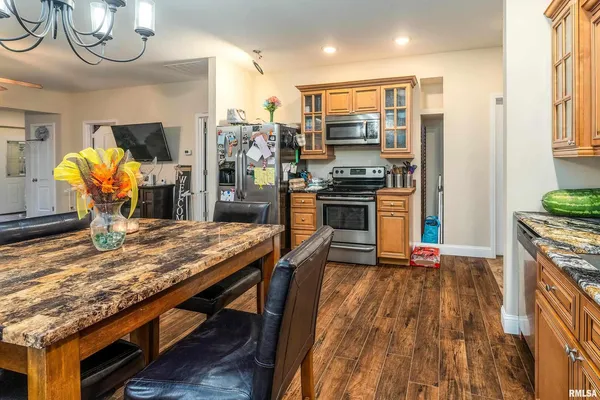 a kitchen with stainless steel appliances granite countertop a stove refrigerator and a fireplace
