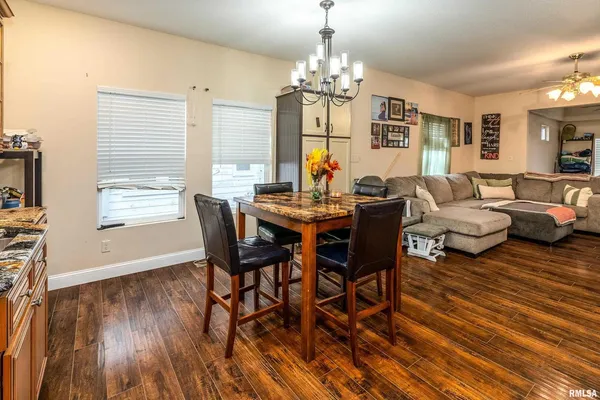 a view of a dining room with furniture a chandelier and wooden floor