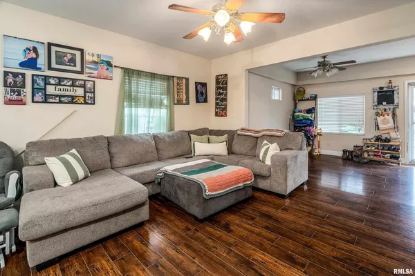 a living room with furniture and a wooden floor