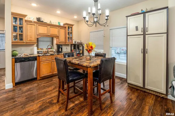 a kitchen with stainless steel appliances a table and chairs in it