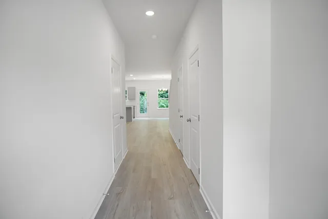 a view of a hallway with wooden floor