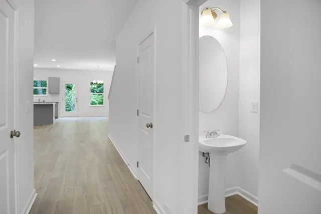 a view of a hallway with wooden floor and a sink