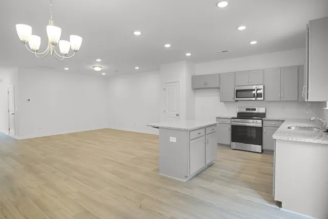 a kitchen with granite countertop white cabinets and stainless steel appliances
