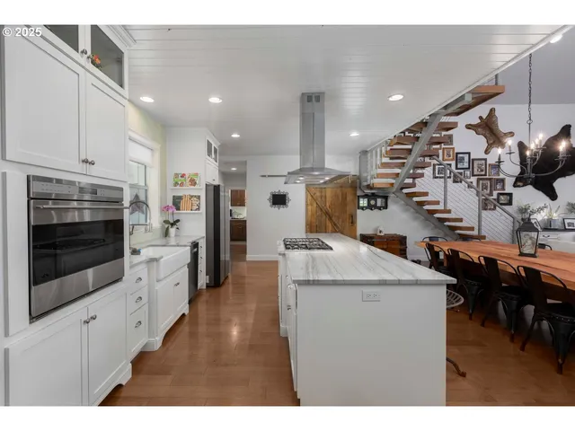 a open kitchen with stainless steel appliances kitchen island granite countertop a refrigerator a stove and a sink