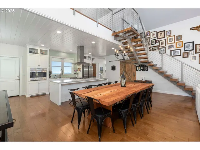 a dining hall with stainless steel appliances kitchen island a table and chairs