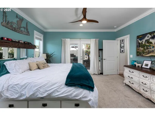 a bedroom with a bed and a flat tv screen on dresser