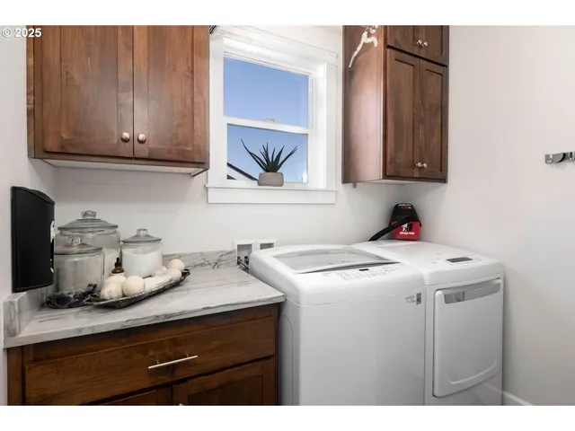 a utility room with cabinets washer and dryer