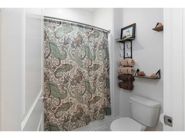 a bathroom with a toilet and shower curtain