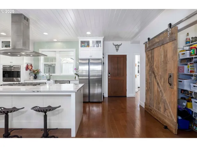a kitchen with stainless steel appliances kitchen island a refrigerator and a cabinets