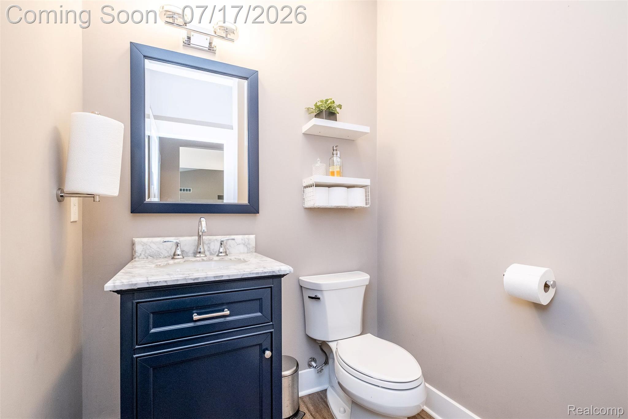 12349 Sugar Maple Drive Fenton, MI 48430 - Photo 22 of 67 Bathroom featuring a dark blue vanity with a light-colored countertop, framed mirror, and chrome fixtures