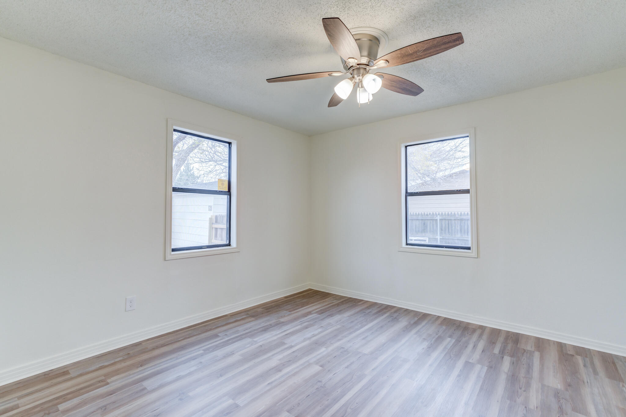 3318 36th Street Lubbock, TX 79413 - Photo 16 of 22 a view of an empty room with wooden floor and a window