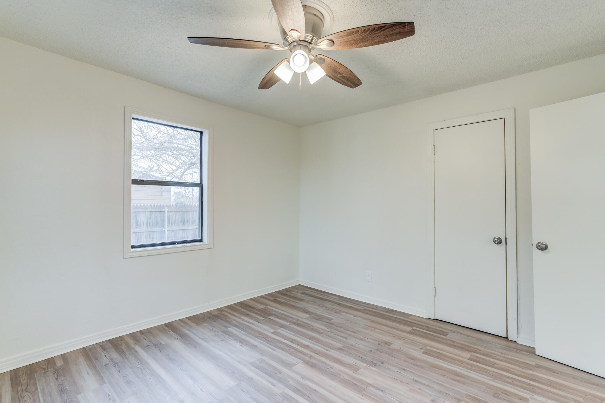 3318 36th Street Lubbock, TX 79413 - Photo 17 of 22 wooden floor in an empty room with a window