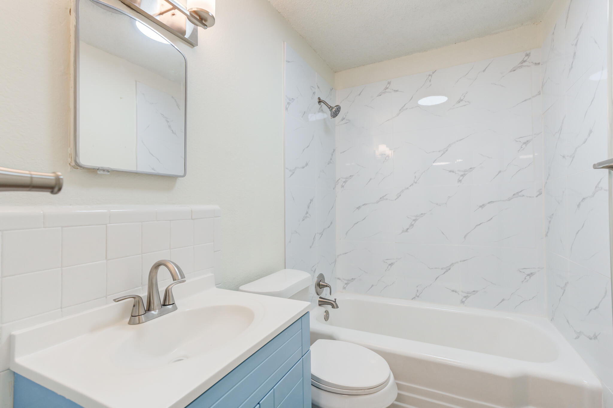3318 36th Street Lubbock, TX 79413 - Photo 19 of 22 a bathroom with a bathtub shower sink vanity mirror and toilet