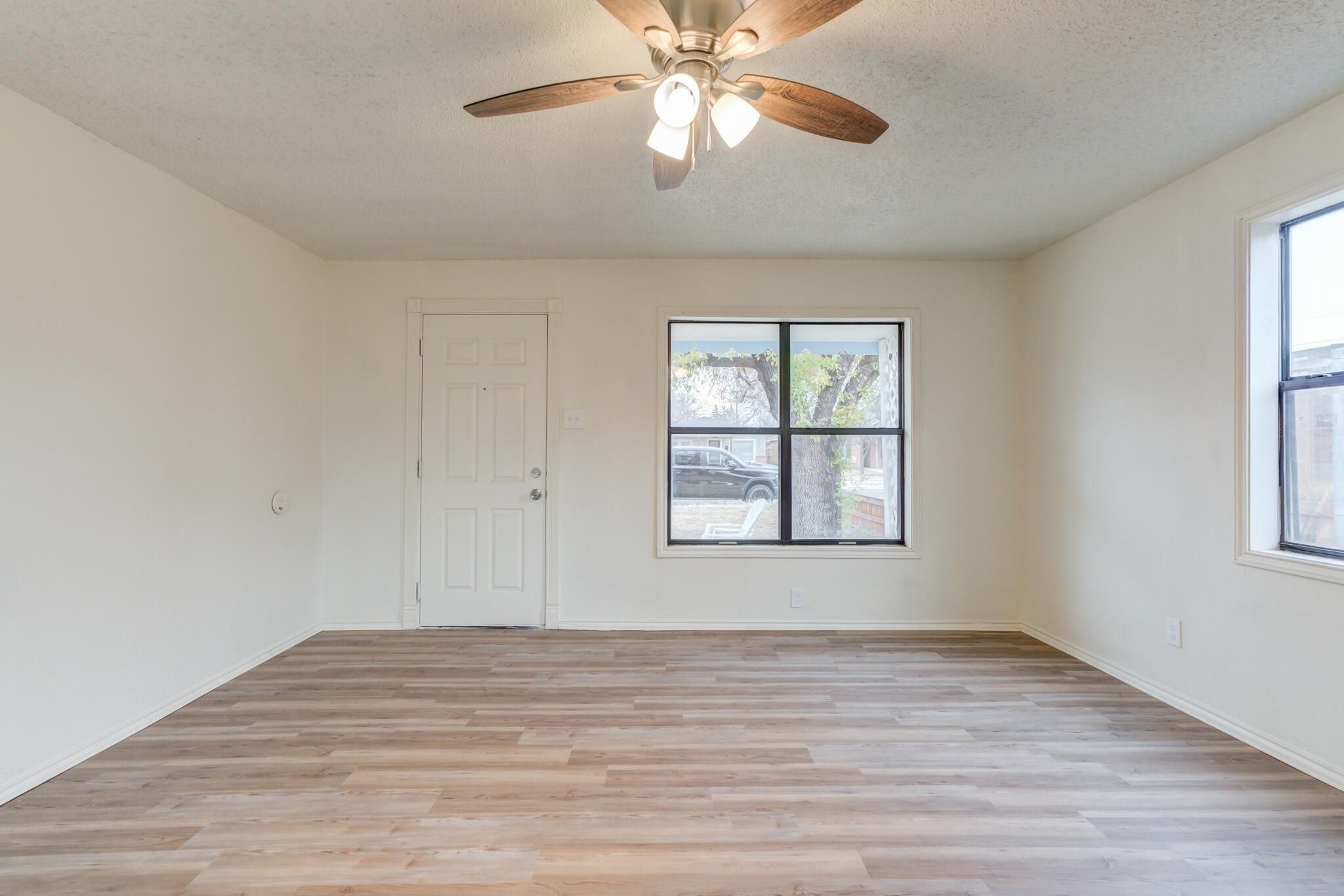 3318 36th Street Lubbock, TX 79413 - Photo 8 of 22 a view of empty room with wooden floor and fan