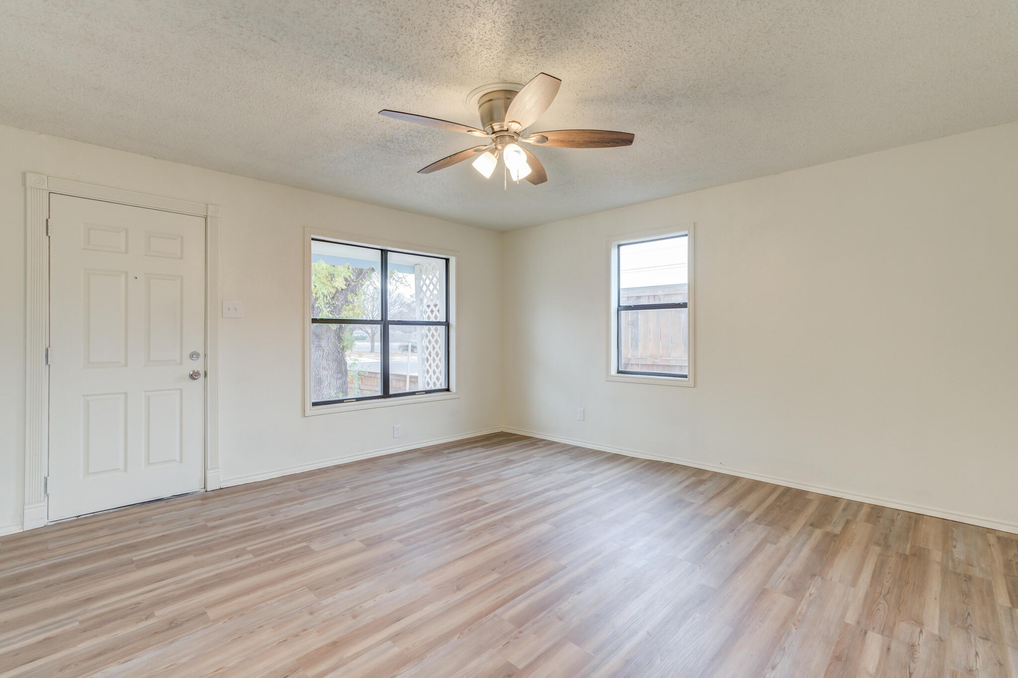 3318 36th Street Lubbock, TX 79413 - Photo 9 of 22 a view of an empty room with wooden floor and a window