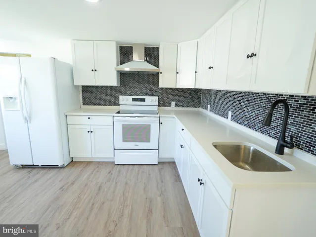 a kitchen with a sink a stove and cabinets