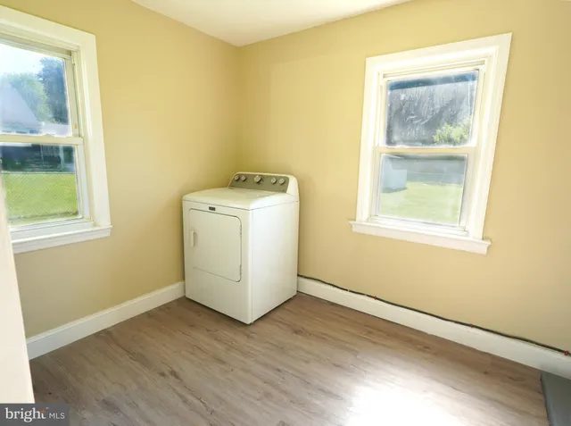 a view of a room that has a window and wooden floor