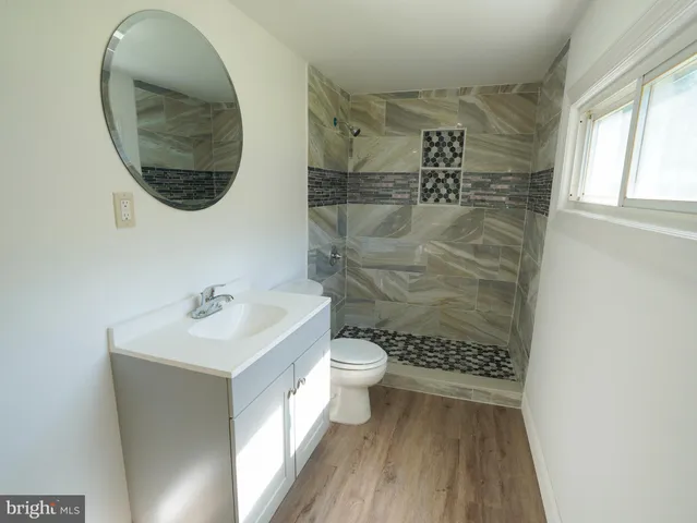 a bathroom with a toilet a sink and mirror