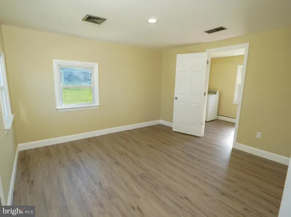 an empty room with wooden floor and a window