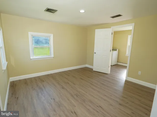 an empty room with wooden floor and a window
